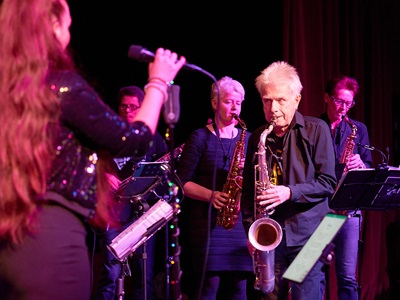 Harry Wesolowski spielt ein Saxophon Solo im Spotlight vor Uli und Barbara